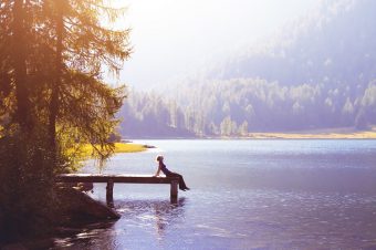 Happy,Woman,Sitting,On,The,Pier,And,Smiling,,Happiness,Or