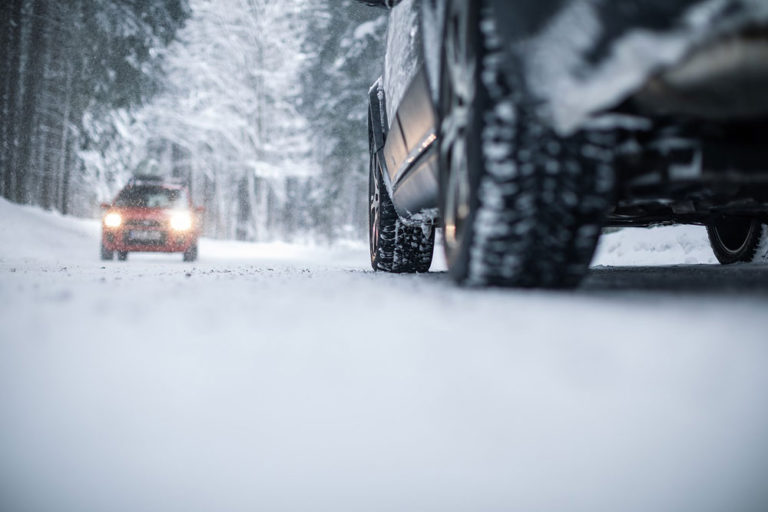 Coche circulando por carretera con nieve, riesgos laborales